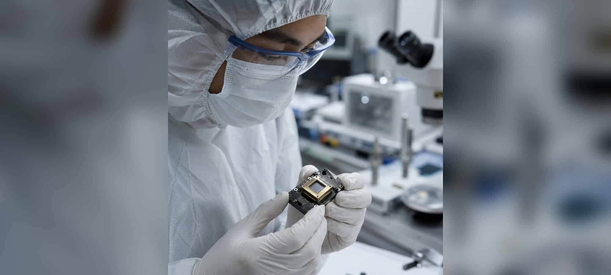 Engineer in a cleanroom inspecting a custom photodiode sensor assembly